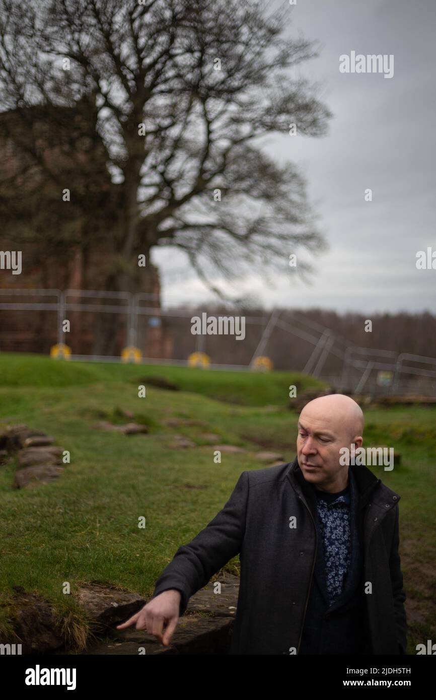 Christopher Brookmyre, autor, en el castillo de Bothwell, cerca de su casa en Bothwell, Escocia, 2 de marzo de 2022. Foto de stock