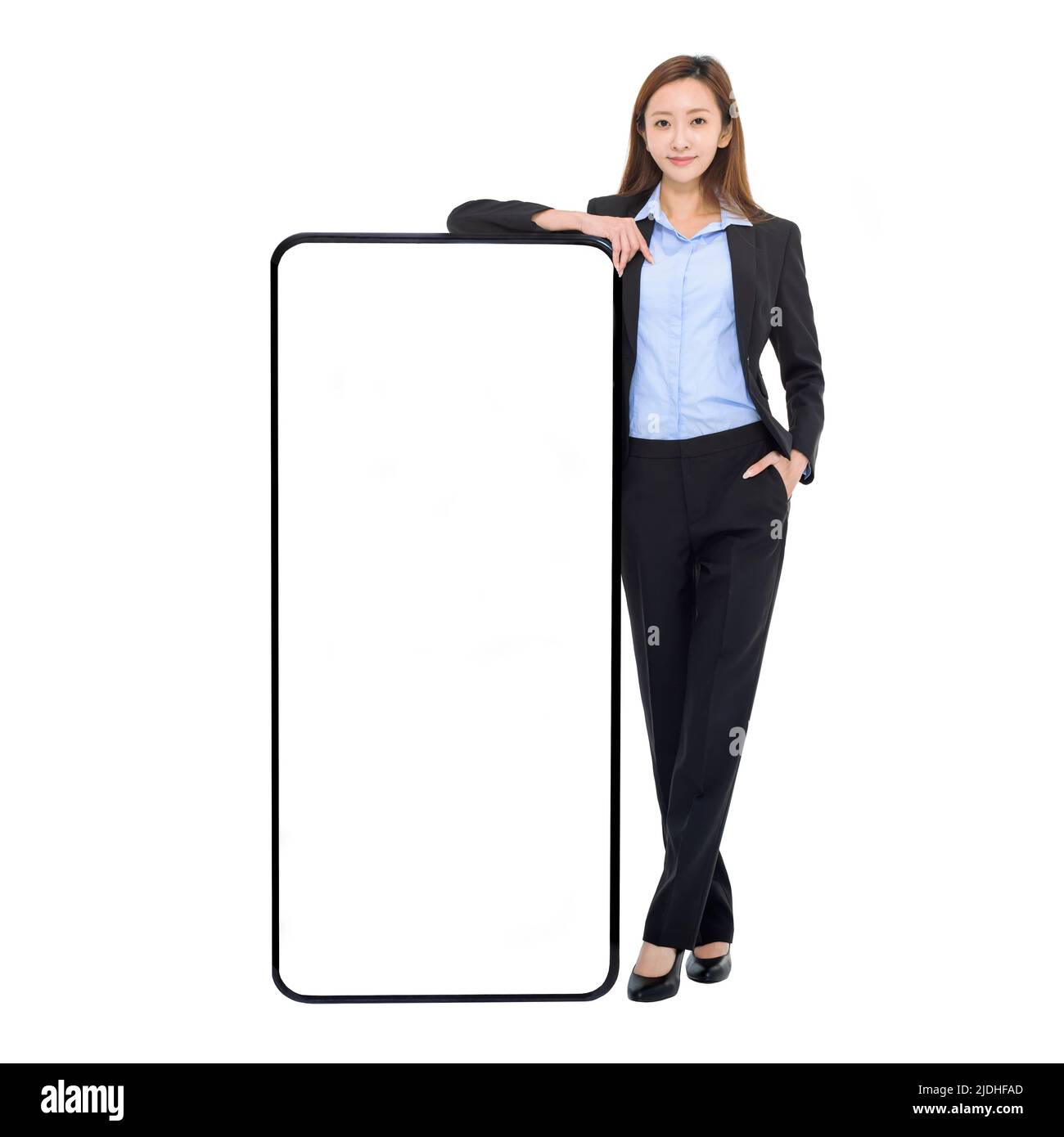 Mujer de negocios que se apoya en un enorme teléfono móvil con pantalla blanca en blanco, recomendando una nueva aplicación o sitio web para el teléfono inteligente Foto de stock