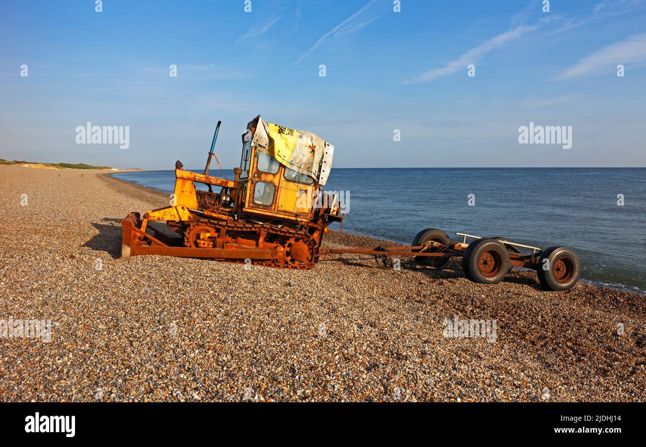 Vista de un tractor de orugas y un remolque de barcos de pesca junto a la costa en la playa de guijarros en North Norfolk en Weybourne, Norfolk, Inglaterra, Reino Unido. Foto de stock