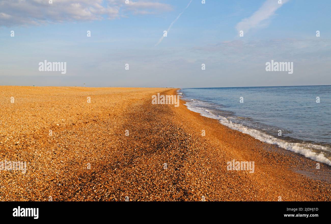 Una vista a lo largo de la extensa playa de guijarros y la costa en verano en la costa de North Norfolk en Cley-next-the-Sea, Norfolk, Inglaterra, Reino Unido. Foto de stock