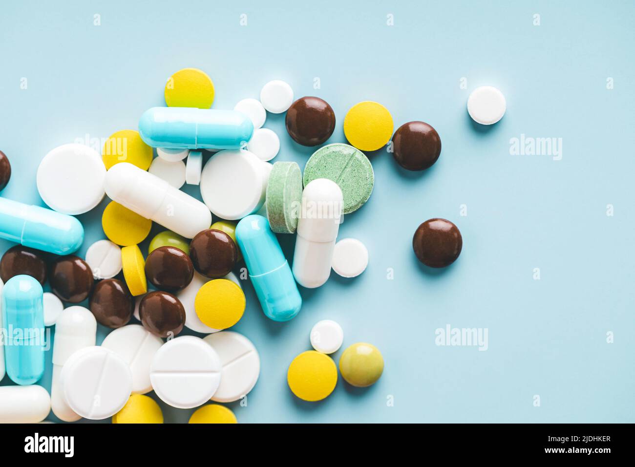 Varias pastillas sobre fondo azul, vista superior. Foto de stock