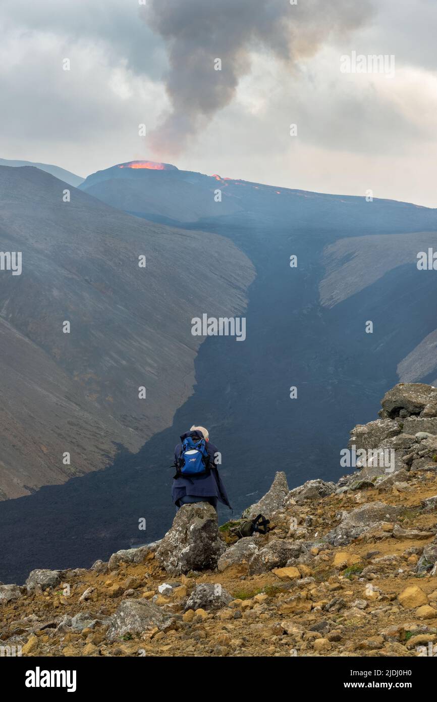Excursionista observando el volcán Fagradalsfjall durante la erupción en agosto de 2021, Islandia Foto de stock