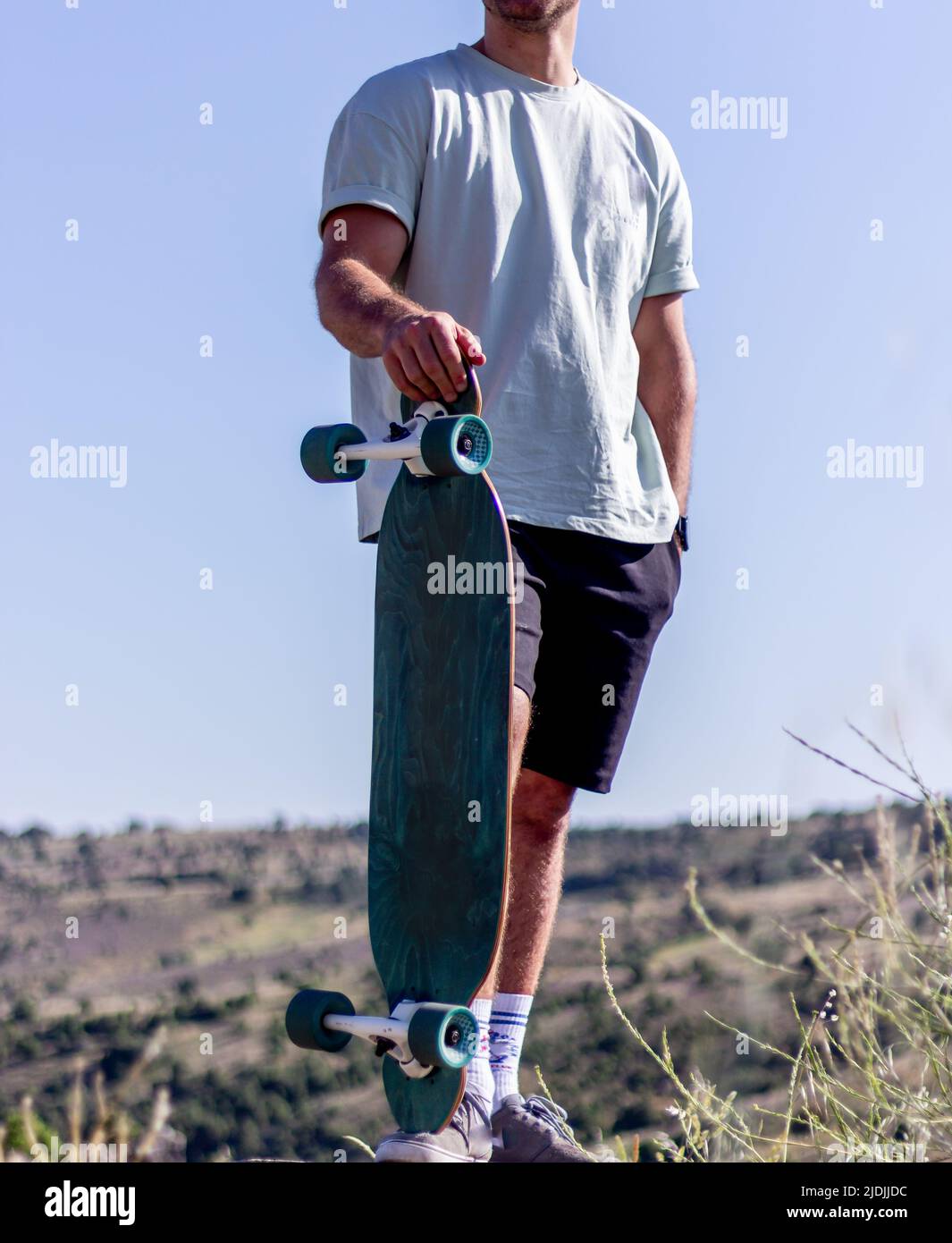 Hombre europeo en una camiseta corta con un longboard Fotografía de stock -  Alamy