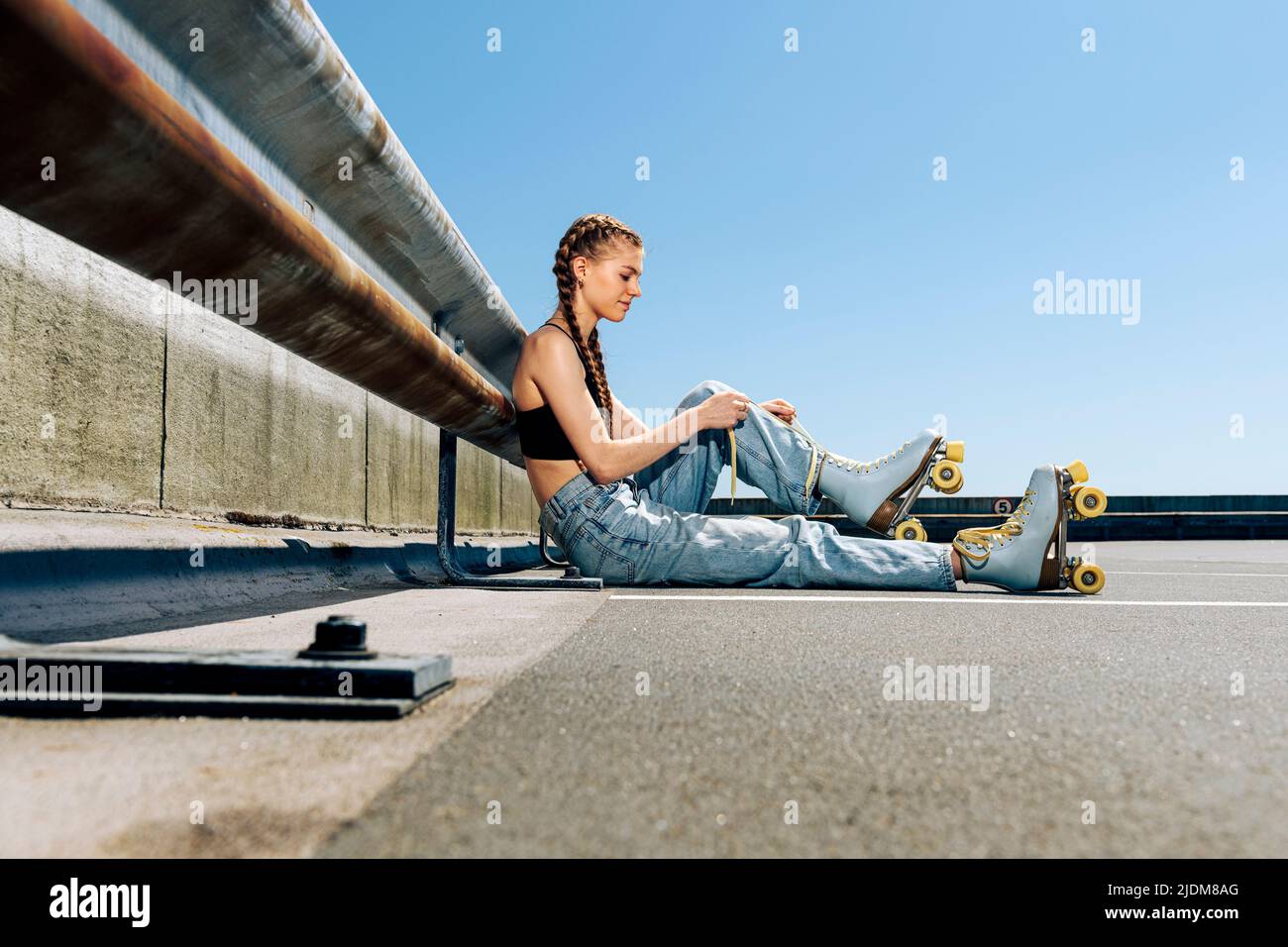 Chica atando sus patines de rodillos, fondo urbano Foto de stock