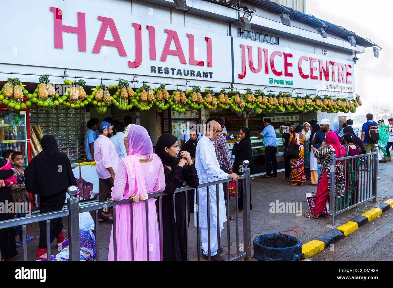 Mumbai, Maharashtra, India : La gente se encuentra en la tienda del centro de zumos Hajiali, junto al acceso al Haji Ali Dargah y el lugar de peregrinación. Foto de stock