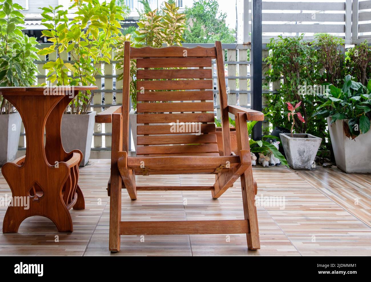 La silla de madera reclinable en la terraza con el pequeño jardín se  encuentra alrededor de la casa urbana para relajarse después del tiempo de  trabajo, vista frontal con la c Fotografía
