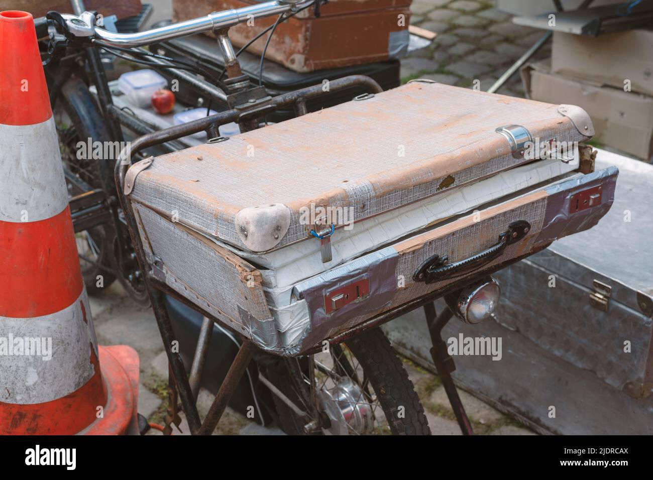 maleta desgastada de época en bicicleta vieja en el mercadillo Foto de stock