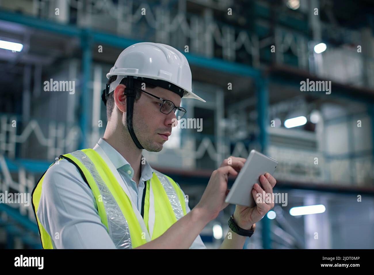 Primer plano de un ingeniero técnico masculino que trabaja en una tableta digital en la fábrica Foto de stock