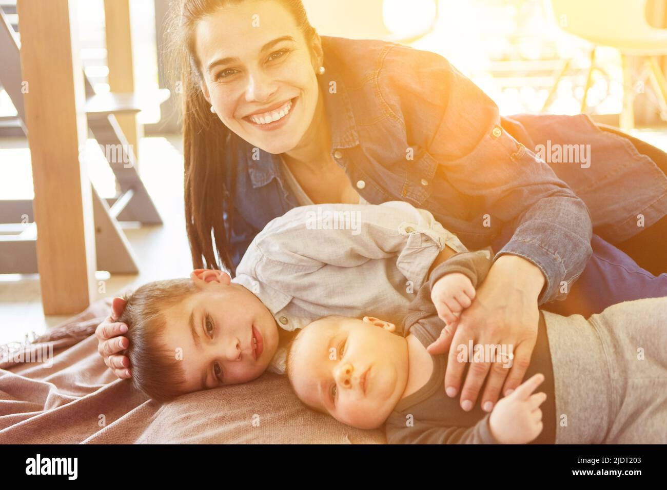Feliz madre soltera con bebé y niño en casa Foto de stock