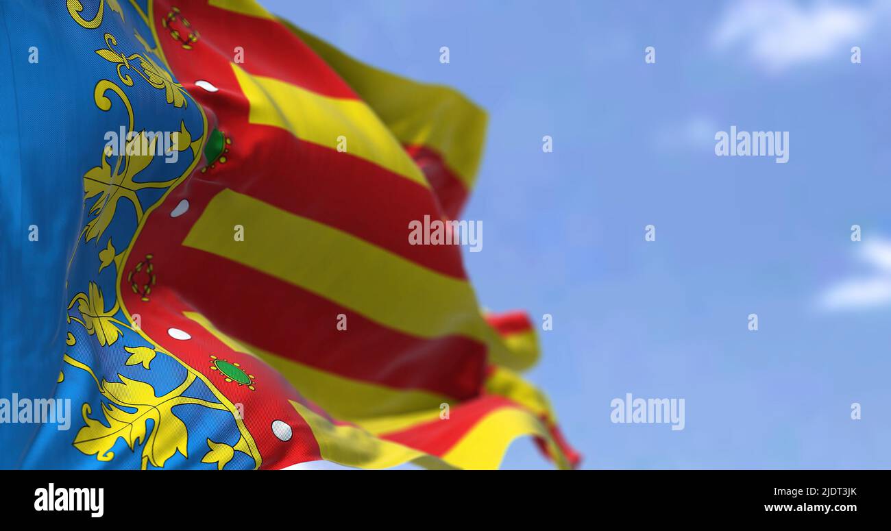 La bandera de la Comunidad Valenciana ondeando en el viento en un día claro. La Comunidad Valenciana es una comunidad autónoma de España. Bucle sin costuras en mot. Lento Foto de stock