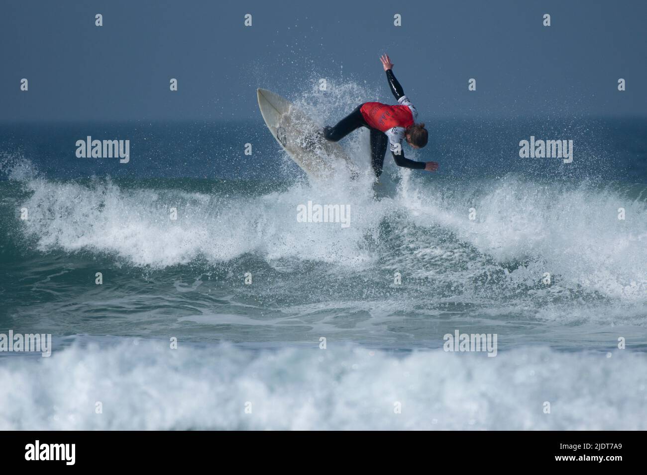 Un surfista masculino que compite en una competición de surf en Fistral en Newquay en Cornwall en el Reino Unido. Foto de stock