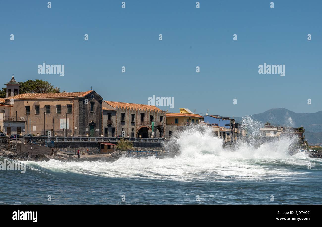 Mar rugoso en el bonito pueblo costero de Torre Archirafi, al norte de Catania, Sicilia, Italia Foto de stock