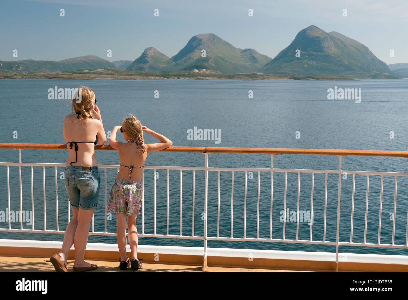 Dos niñas disfrutan del hermoso paisaje a lo largo de la costa de Möre mientras viajan con Hurtigruten a lo largo de la costa de Noruega en el verano de 2008. Foto de stock