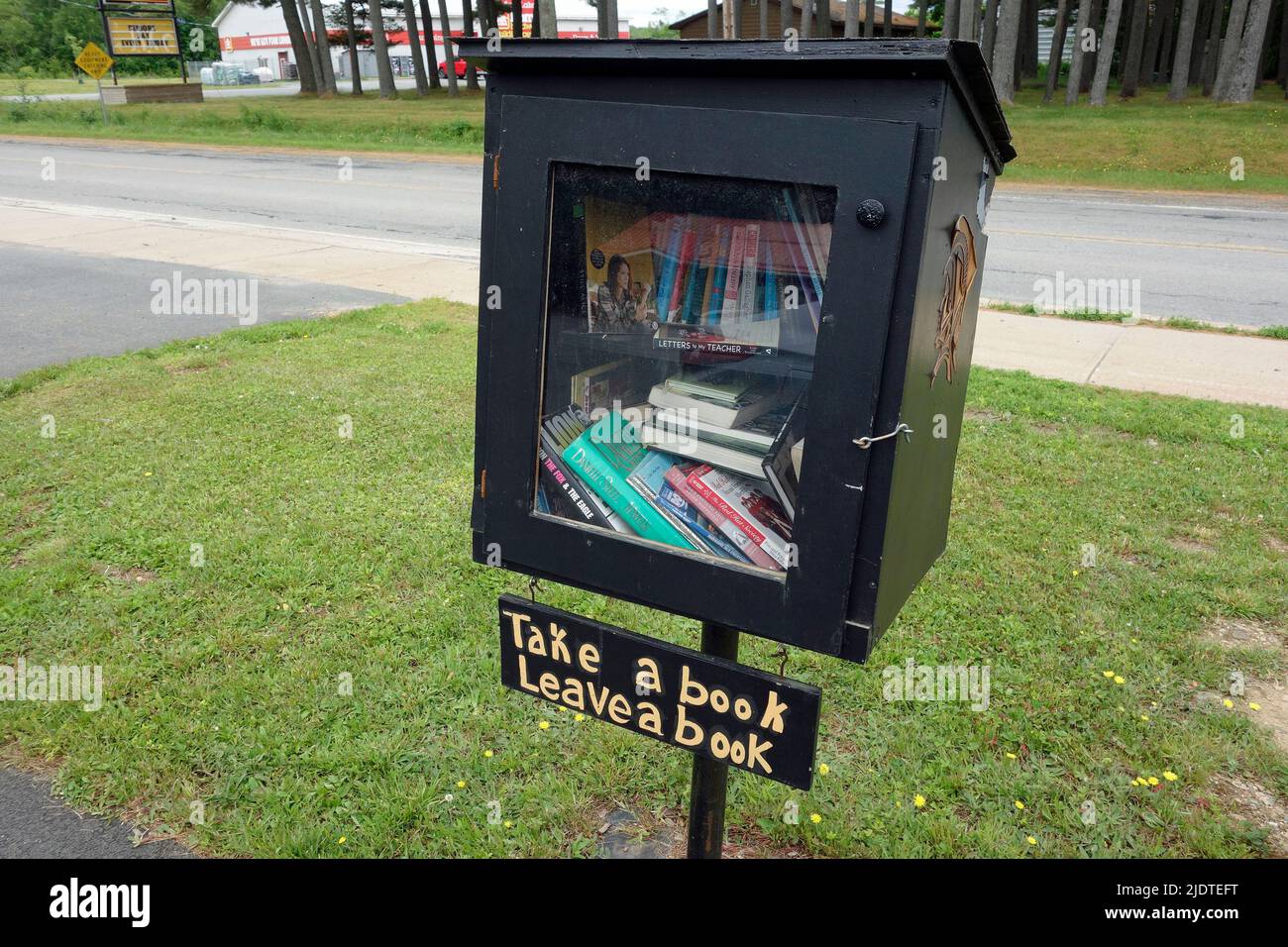 Tome un libro Dé un libro junto a la carretera de la biblioteca Nueva Escocia Canadá en Caledonia Foto de stock