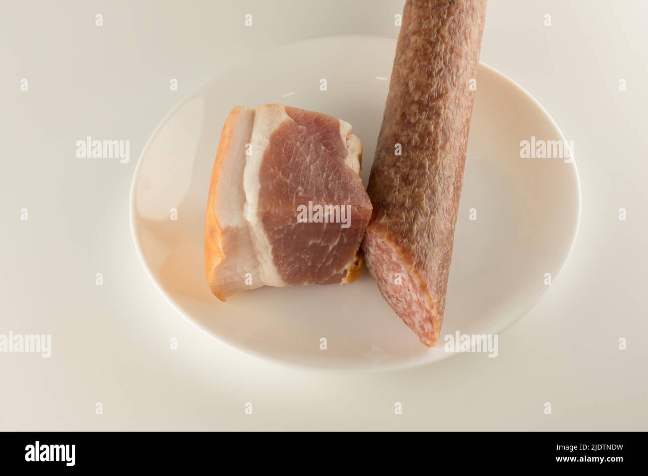 salchicha con un trozo de carne en un plato Foto de stock