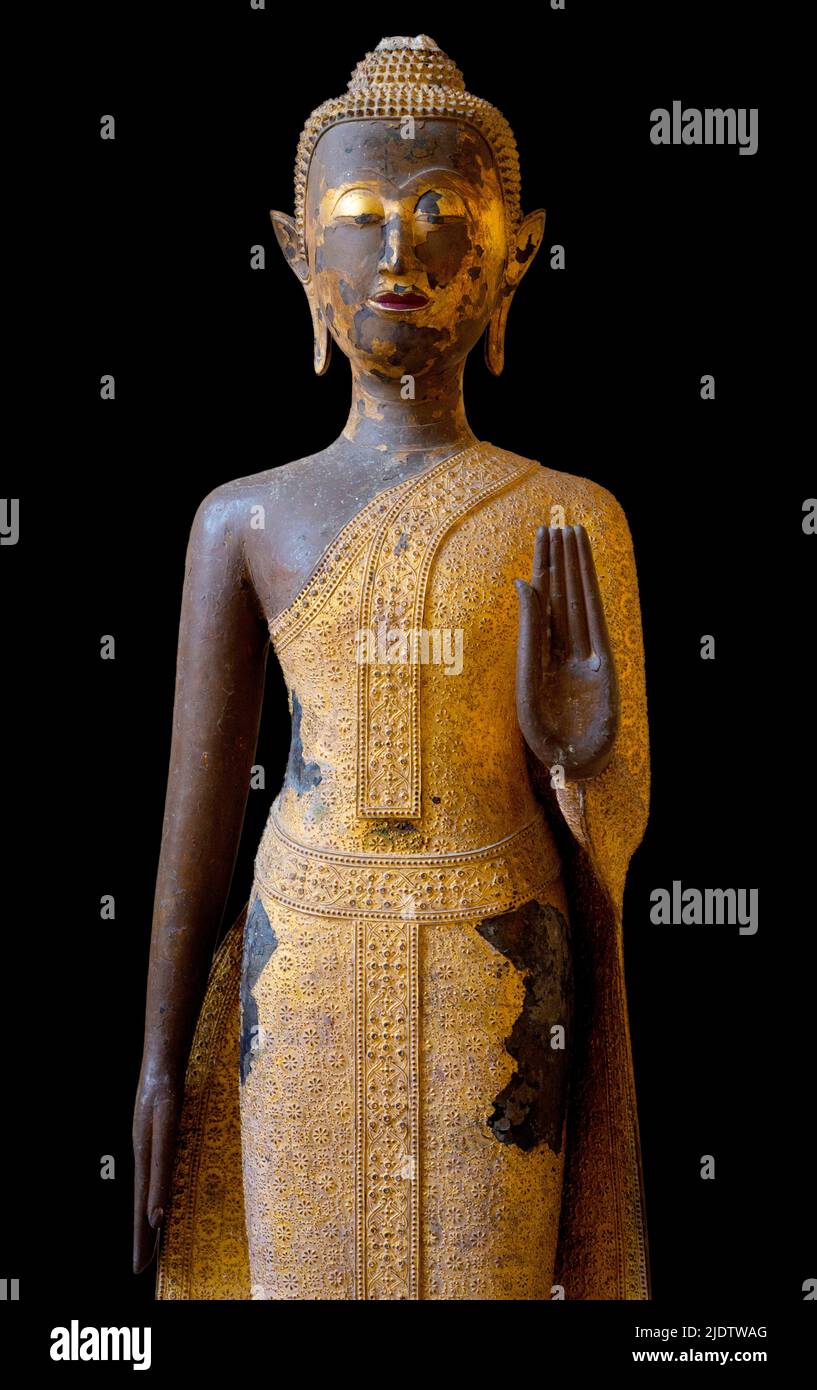 Antiguo buda tallado en madera en el templo tailandés sobre fondo negro. Foto de stock