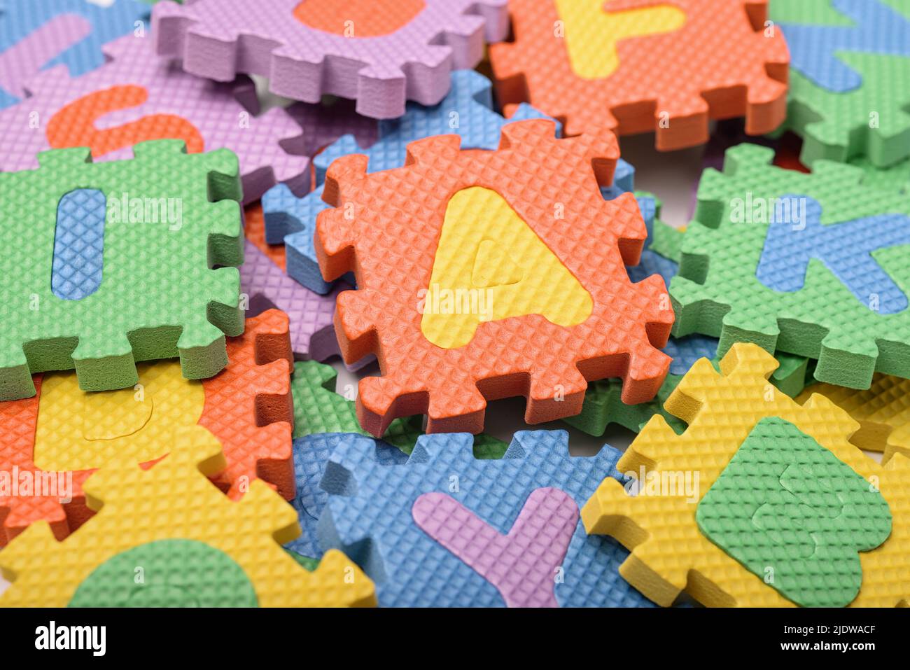 Primer plano de piezas de puzzle de letras de espuma de colores Foto de stock