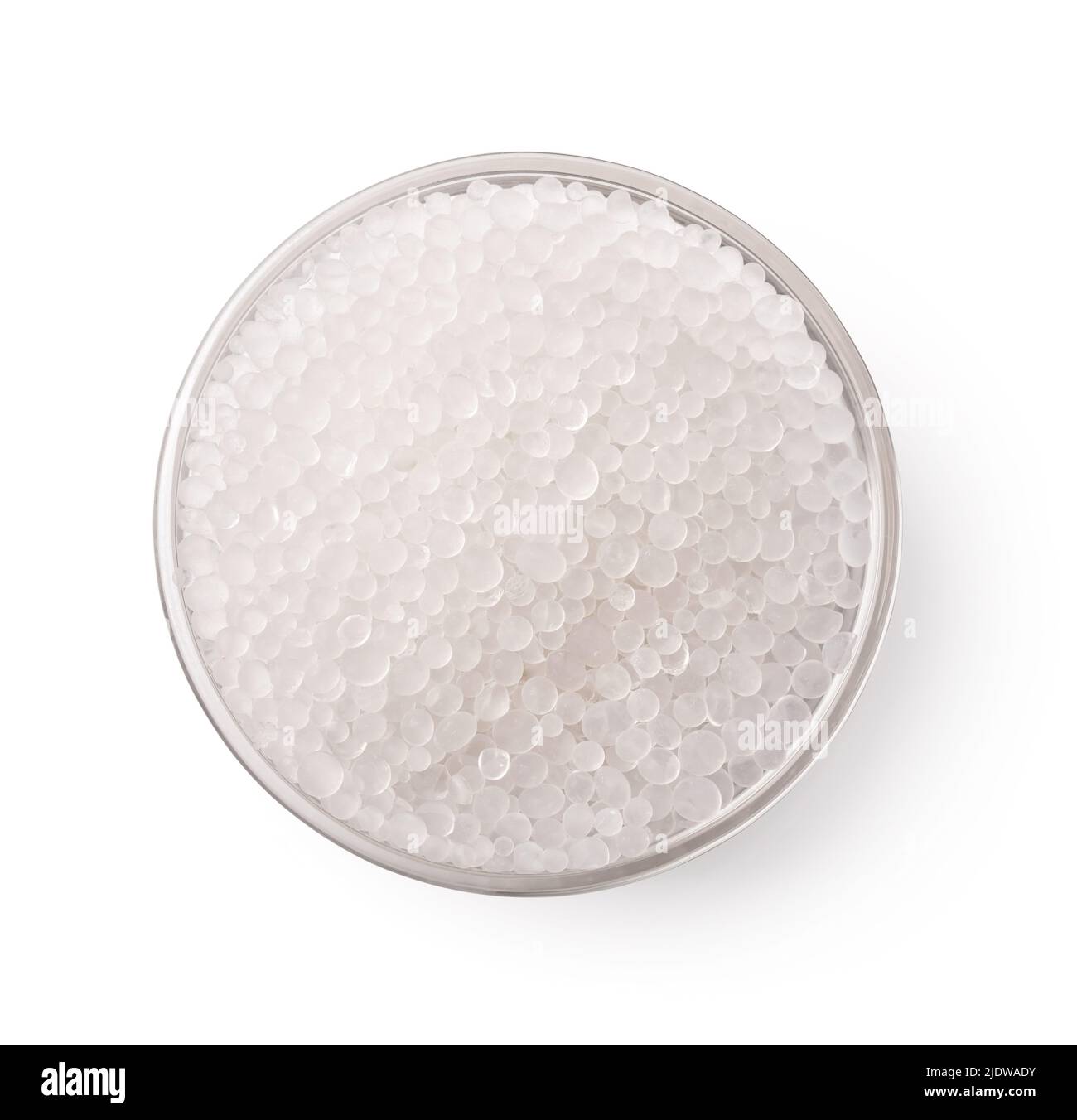 Vista superior del recipiente de vidrio de gránulos de silicagel aislados sobre blanco Foto de stock