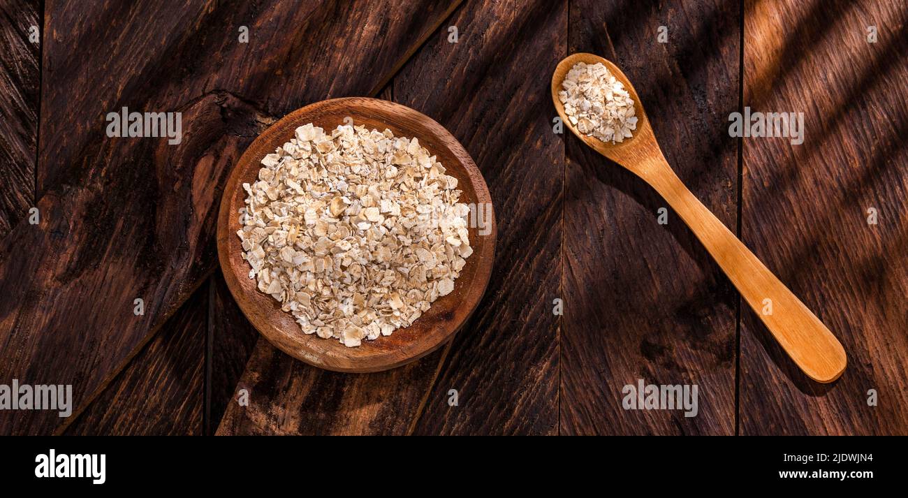 Copos de avena en el tazón de madera - Avena sativa Foto de stock