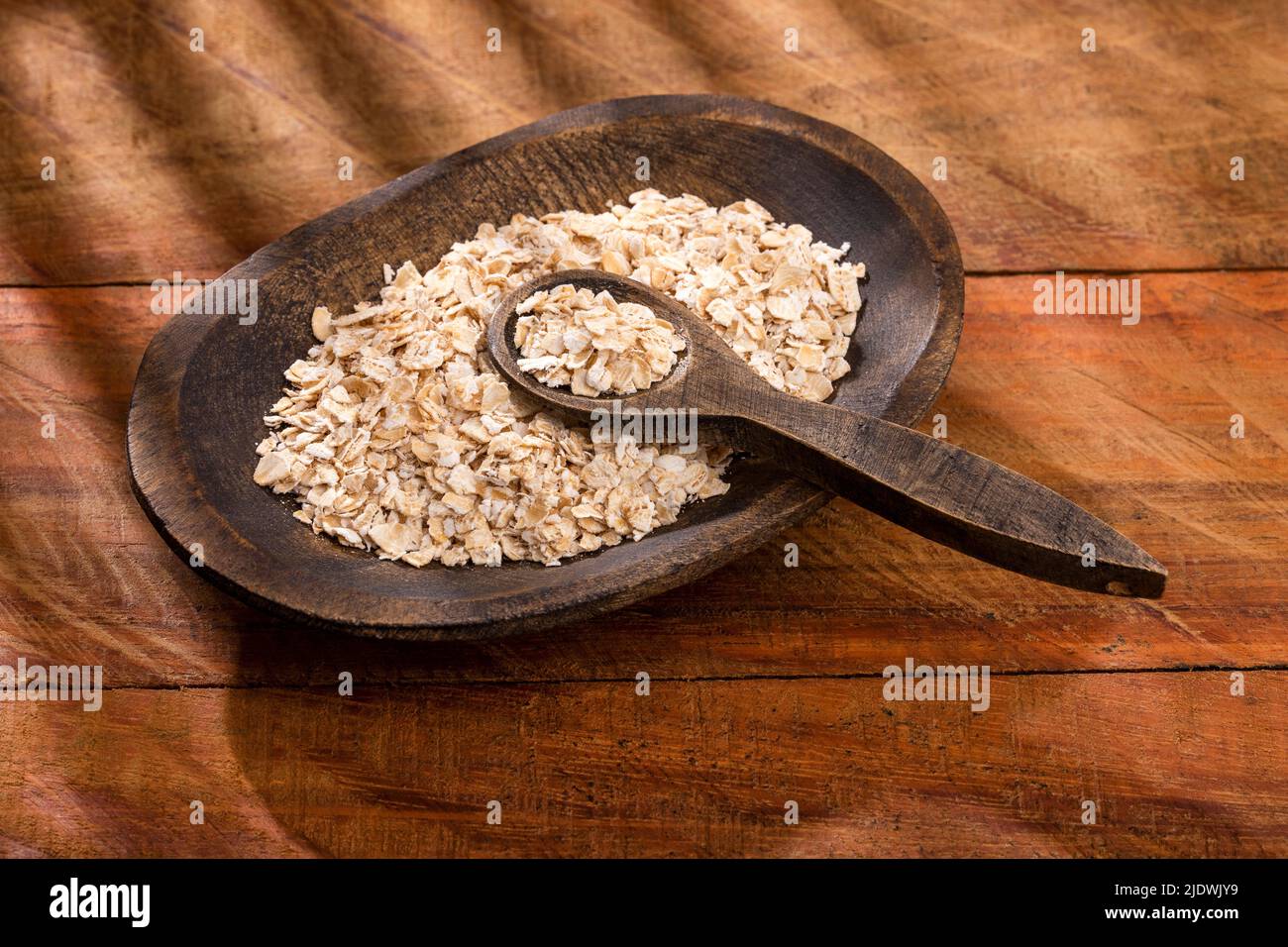 Avena sativa - Escamas de avena en el tazón de madera Foto de stock