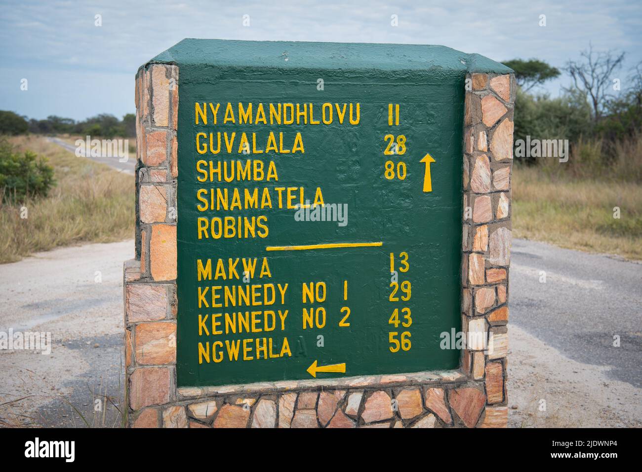 Un cartel que indica los diferentes destinos y sus distancias en el Parque Nacional de Hwange Foto de stock