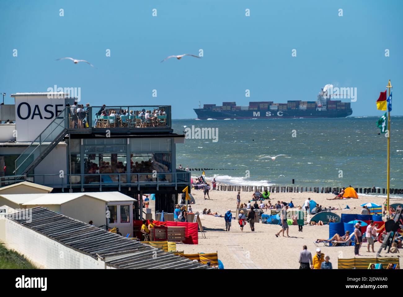 Playa de Domburg, en Zeeland, Holanda del Sur, Países Bajos, en el fondo un carguero de contenedores de la compañía naviera MSC, entra en el Scheldt, remolque Foto de stock