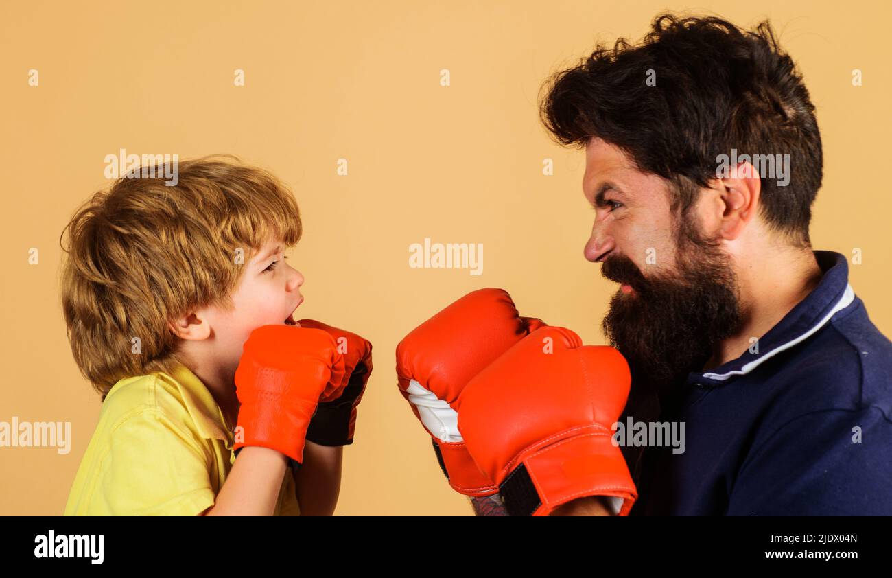 Niño en entrenamiento de guantes de boxeo con entrenador. El instructor enseña al niño. Orificio de perforación. Listo para el sparring Foto de stock