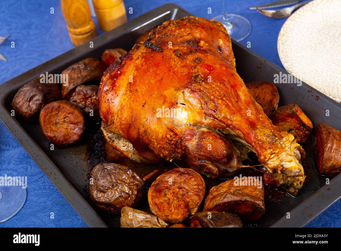 Pata de cerdo al horno con acompañamiento de patatas en bandeja para  hornear Fotografía de stock - Alamy