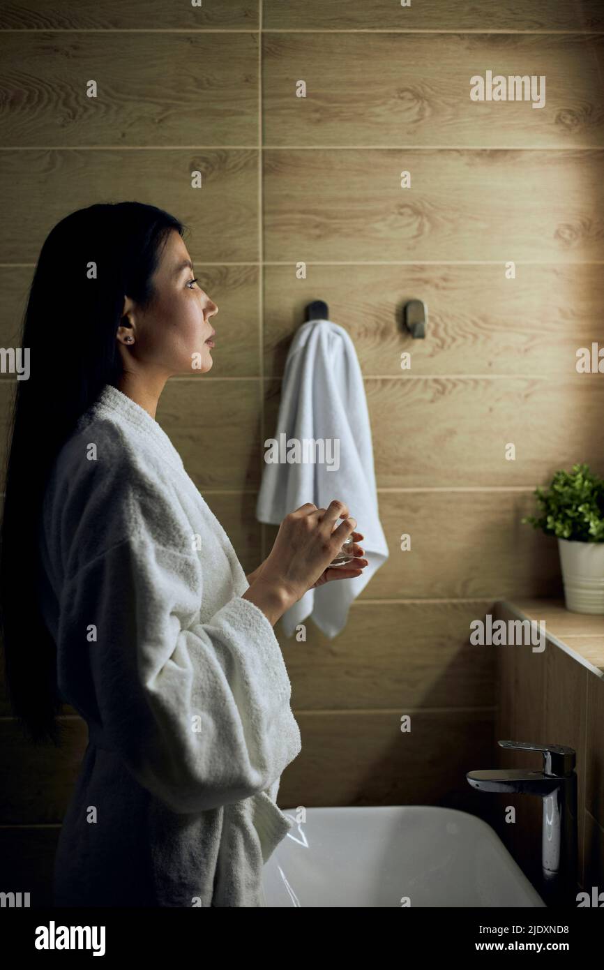 Mujer con albornoz haciendo rutina de cuidado de la piel Foto de stock