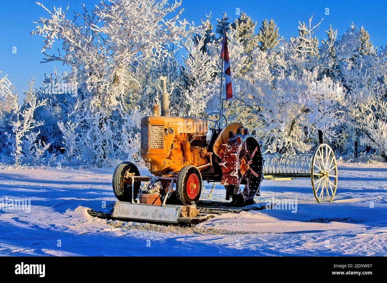 Un antiguo tractor agrícola Moline de Minneapolis aparcado como una pieza decorativa en la pesada helada del norte de Alberta Canadá. Foto de stock