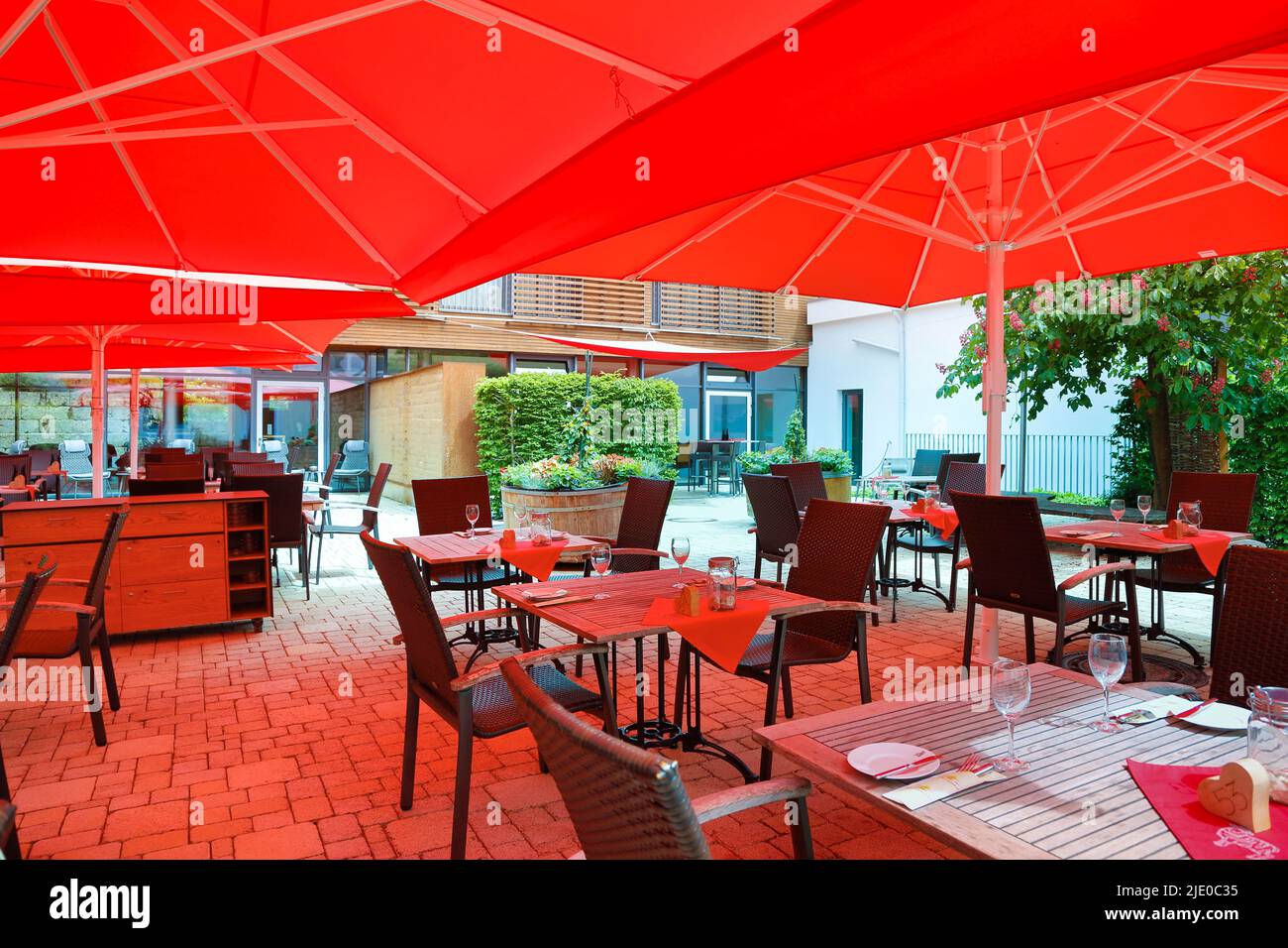 Mesas y sillas en la terraza, hotel, Gasthof Herrmann, gastronomía  exterior, sombrillas rojas, Muensingen en el Alb Suabia, Baden-Württemberg  Fotografía de stock - Alamy
