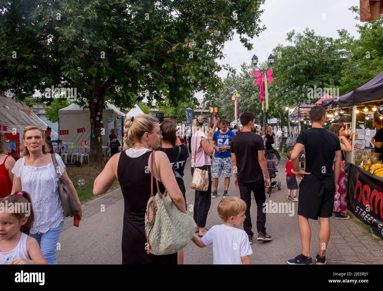 La gente caminando en la acera y comprando de los puestos de comida durante un festival Foto de stock