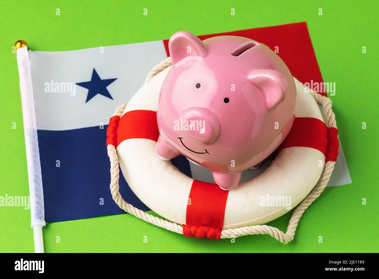 Banco de cerdos, salvavidas y bandera sobre fondo azul, el concepto de salvar la economía panameña Foto de stock