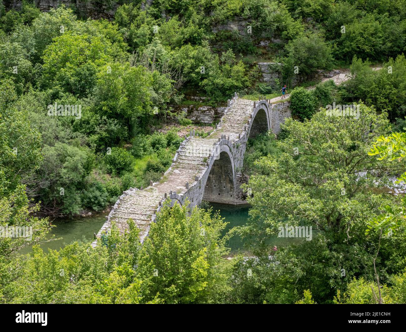 Plakidas o puente Kalogeriko, único en arco triple, en la región de Zagori, en Vikos Gorge, al norte de Grecia Foto de stock