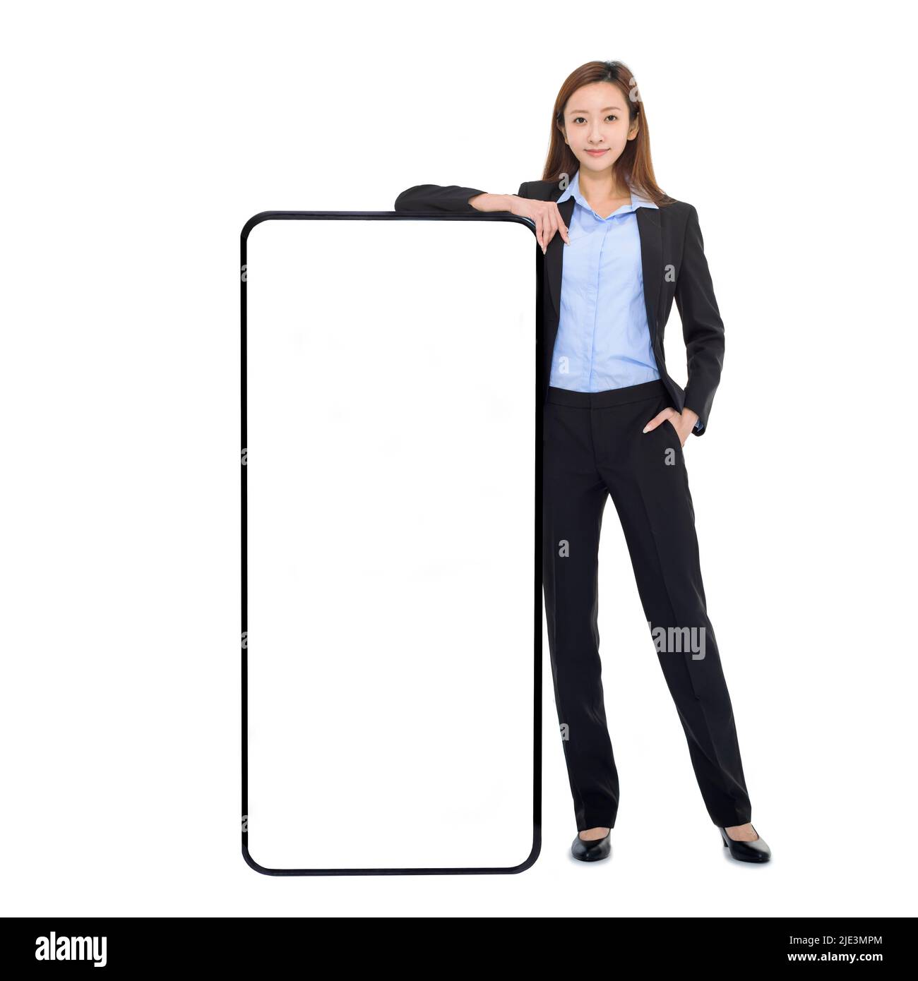 Mujer de negocios que se apoya en un enorme teléfono móvil con pantalla blanca en blanco, recomendando una nueva aplicación o sitio web para el teléfono inteligente Foto de stock