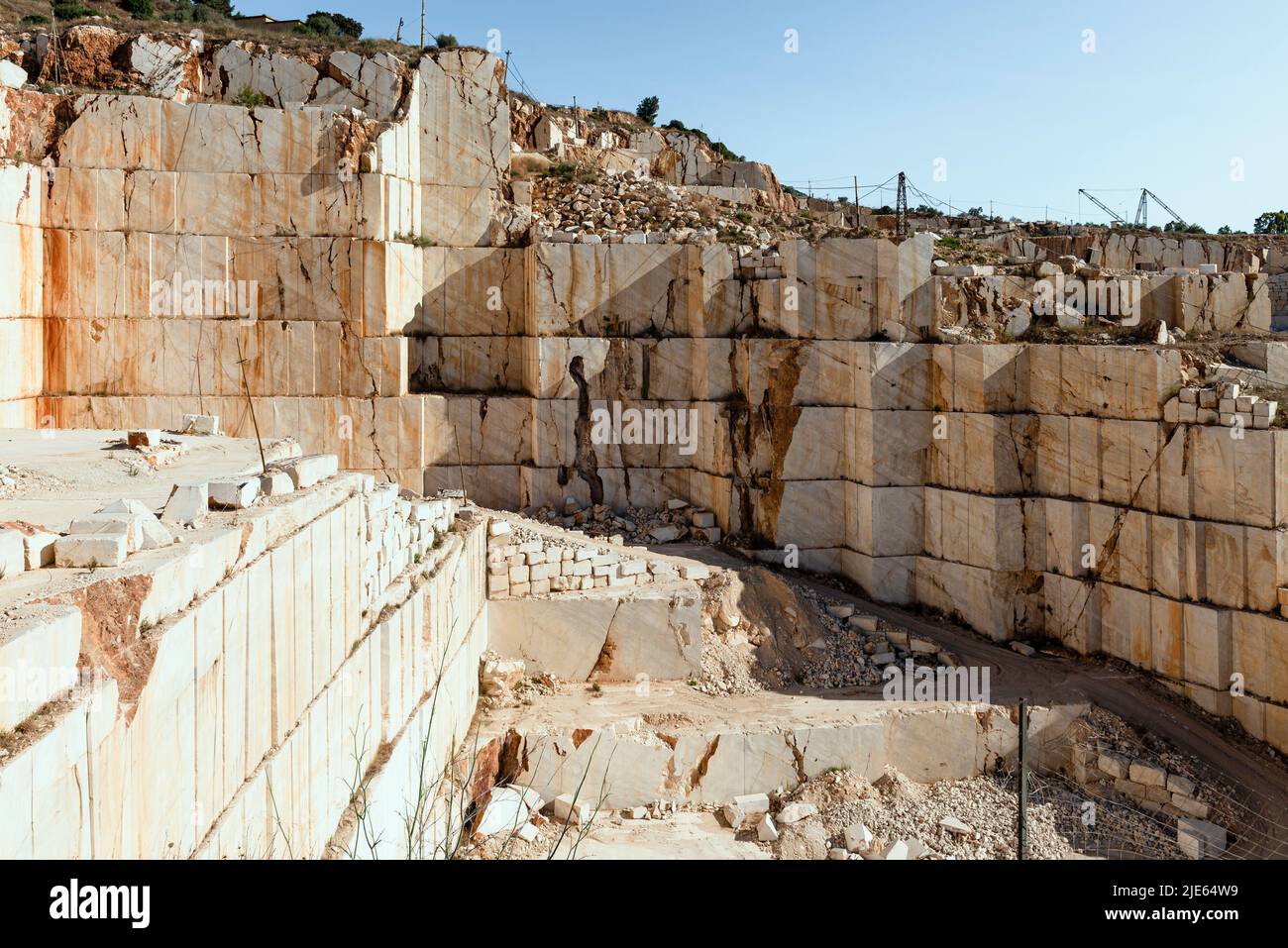 Pared de roca, rampas, bloques y excavadoras en la cantera de mármol cerca de Orosei en la costa este de Cerdeña, Baronia, Italia Foto de stock