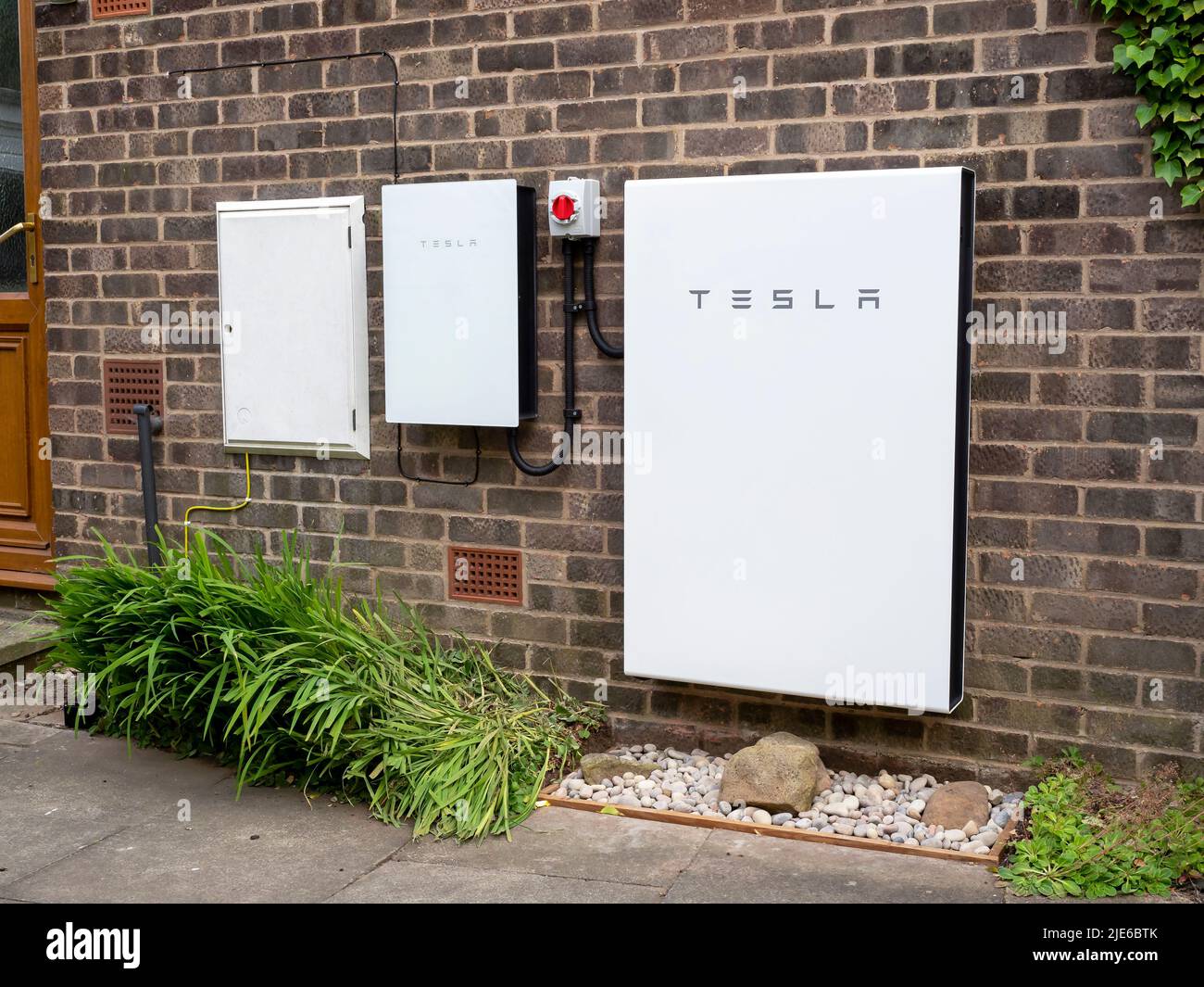 Sistema de almacenamiento de baterías Tesla Powerwall 2 y Backup Gateway 2 instalado en una pared de ladrillo Foto de stock