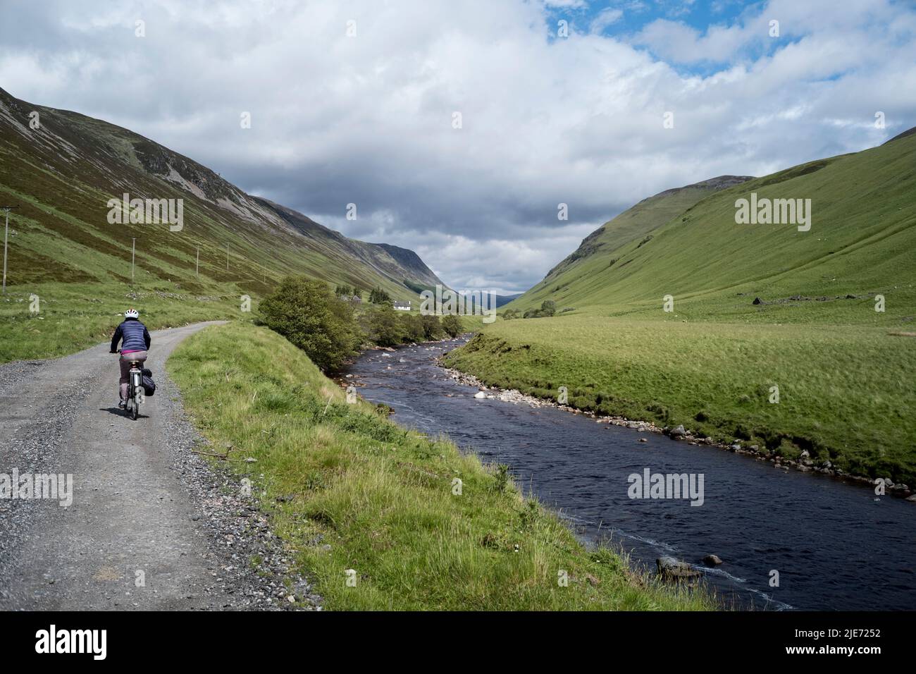 Ciclista en una pista en Glen Tilt, junto a la inclinación del río, cerca de Blair Atholl Perthshire, Escocia. Foto de stock