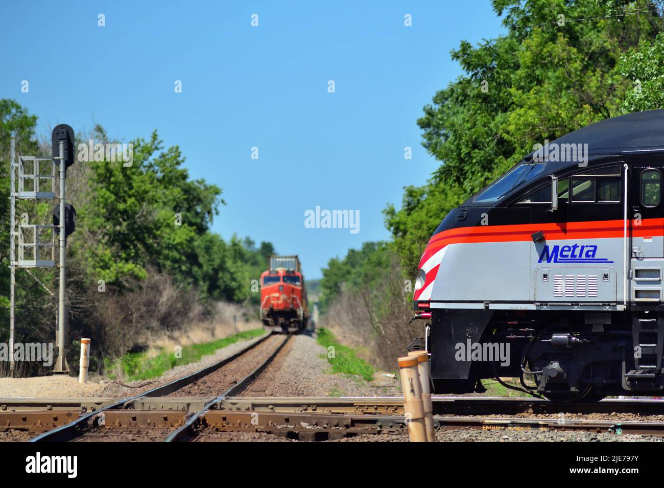 Bartlett, Illinois, EE.UU. Un tren interurbano Metra que pasa por un cruce con el Canadian National Railway en Spaulding Junction. Foto de stock