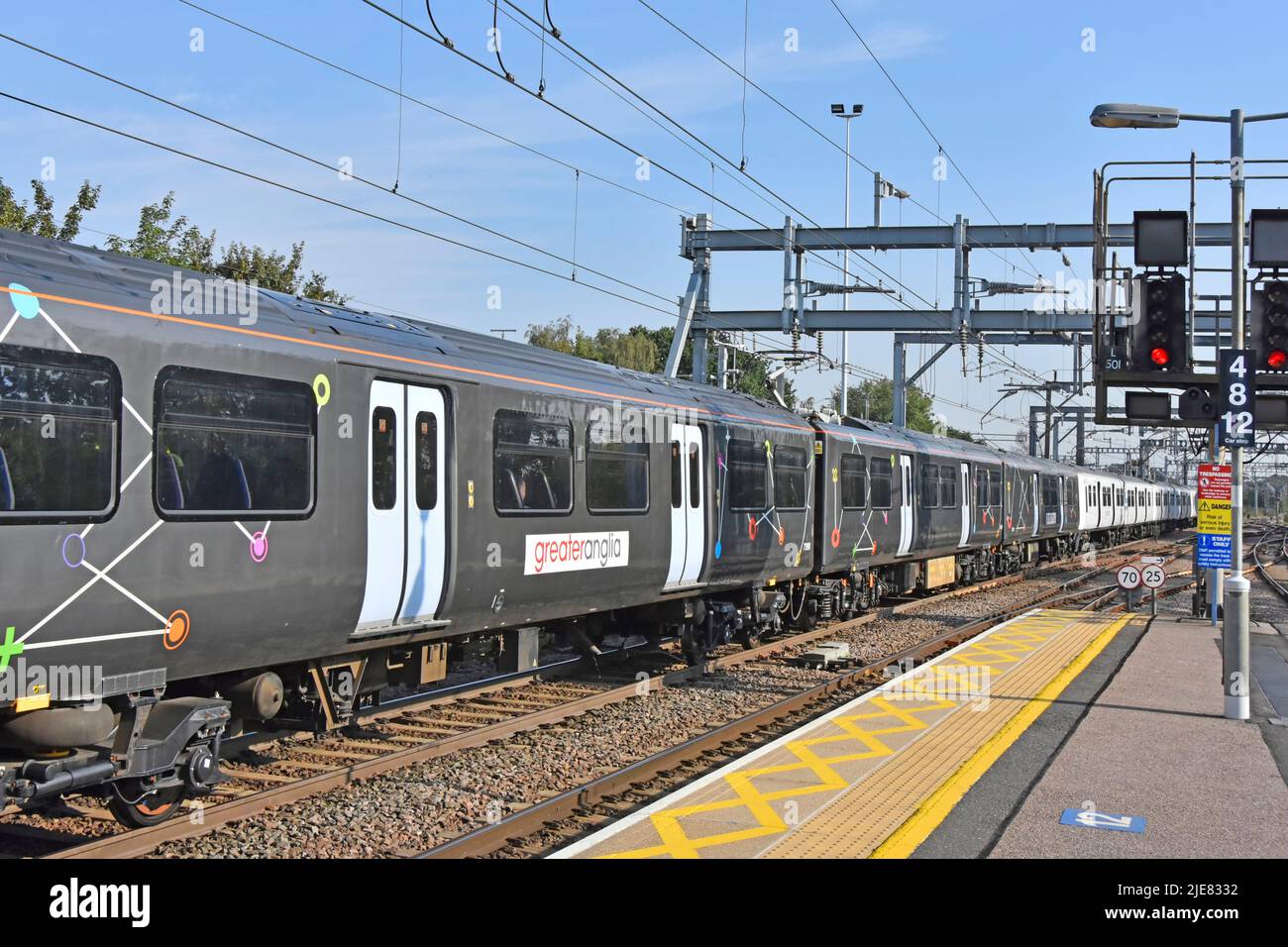 Gran Anglia coches de tren eléctrico en color gris inusual con puertas blancas y gráficos lineales extraños visto en la estación de tren de Shenfield Reino Unido Foto de stock