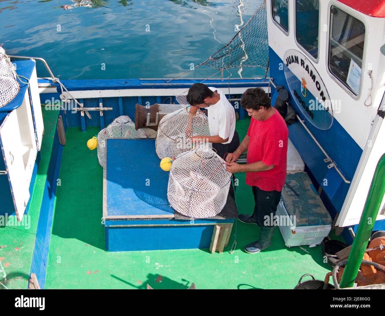 Pescadores reparando sus trampas de peces, barcos de pesca en el puerto de Puerto de Mogan, Gran Canaria, Islas Canarias, España, Europa Foto de stock