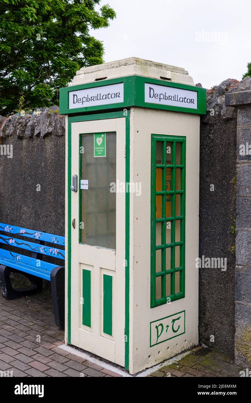 Antigua caja de teléfono irlandesa que se ha convertido en un lugar de almacenamiento seguro para un desfibrilador. Foto de stock