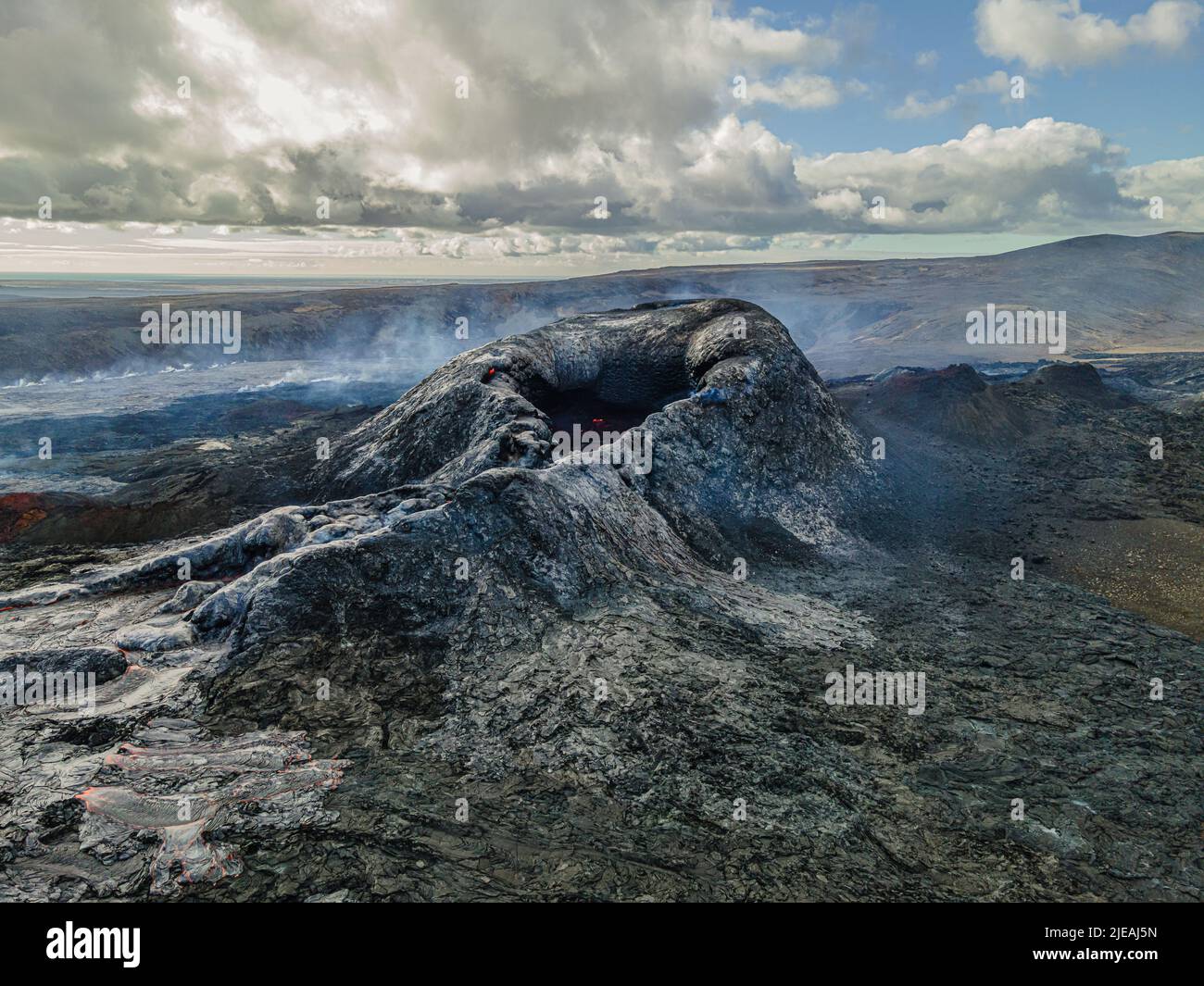 Cráter volcánico en Islandia. Volcán activo en la península de Reykjanes. Paisaje antes de la erupción. Magma enfriada alrededor del volcán. Vista de la cra Foto de stock