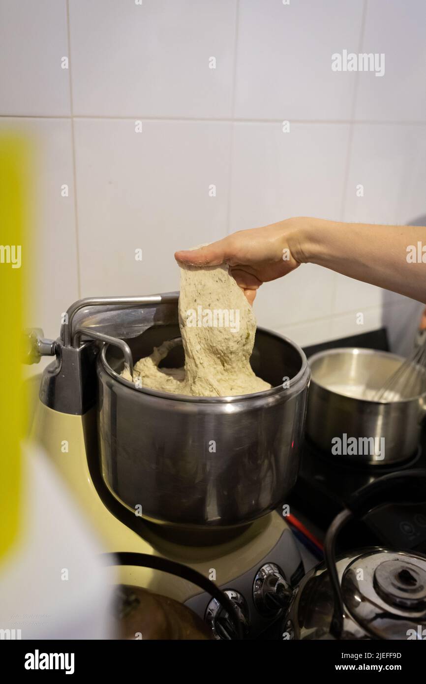 El proceso de hacer pan de trigo en una panadería artesanal. Amasar en una  amasadora de masa. Foto vertical Fotografía de stock - Alamy