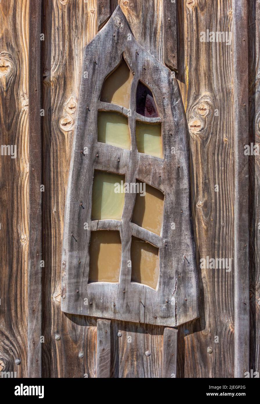 Primer plano de una ventana de madera ornamentada en un ambiente soleado Foto de stock