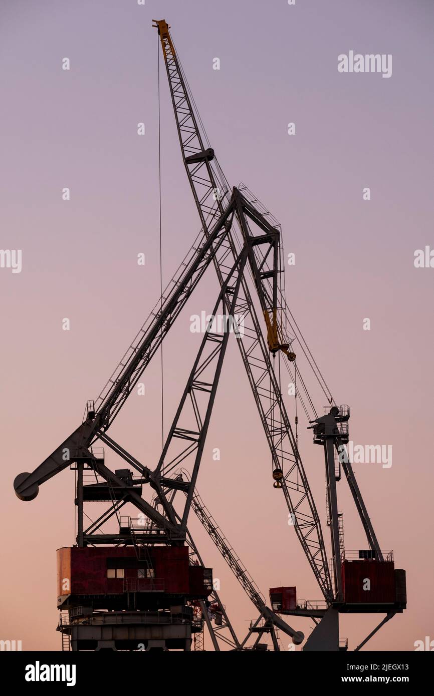 Helsinki / Finlandia - 26 DE JUNIO de 2022: Una silueta de una antigua grúa de astilleros contra la puesta del sol Foto de stock
