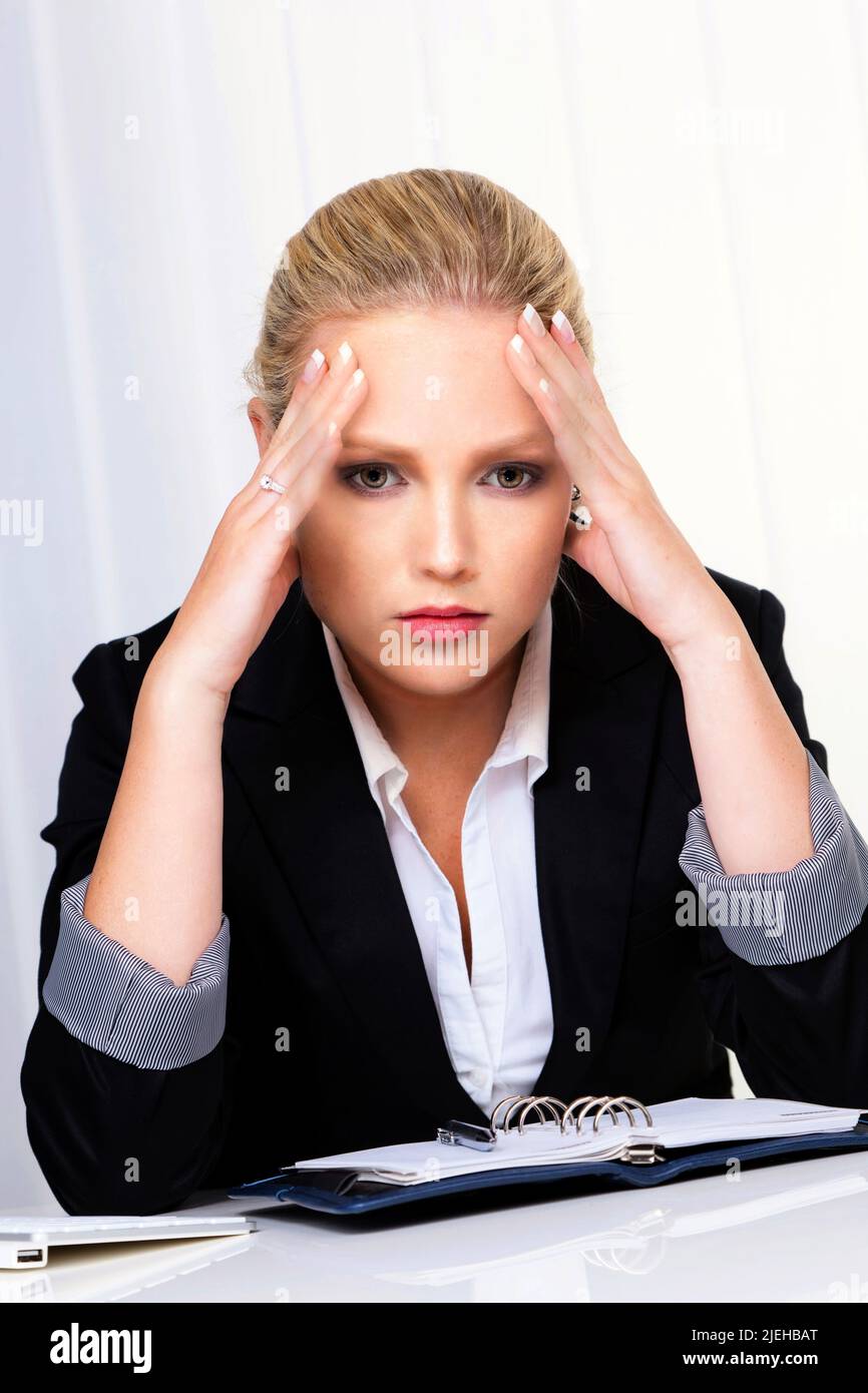 Eine junge Frau im Büro mit Migräne und Kopfschmerzen, Frau, 30, 35, Jahre, Rubia, Blondine, Foto de stock