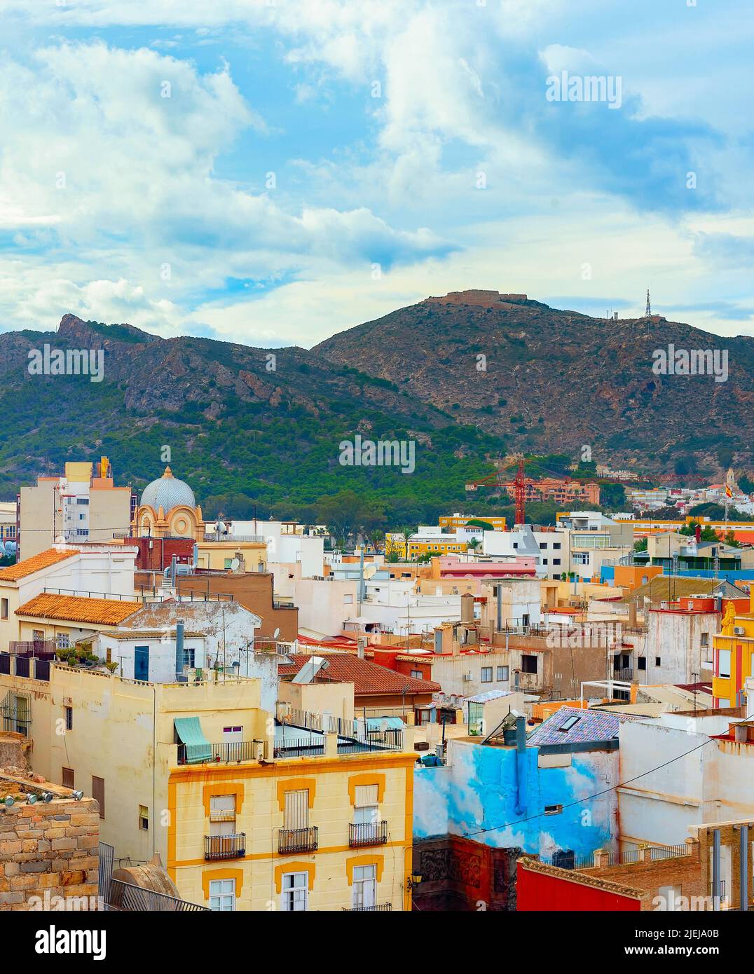 Paisaje urbano con montañas y coloridas casas en el fondo, Cartagena, España Foto de stock