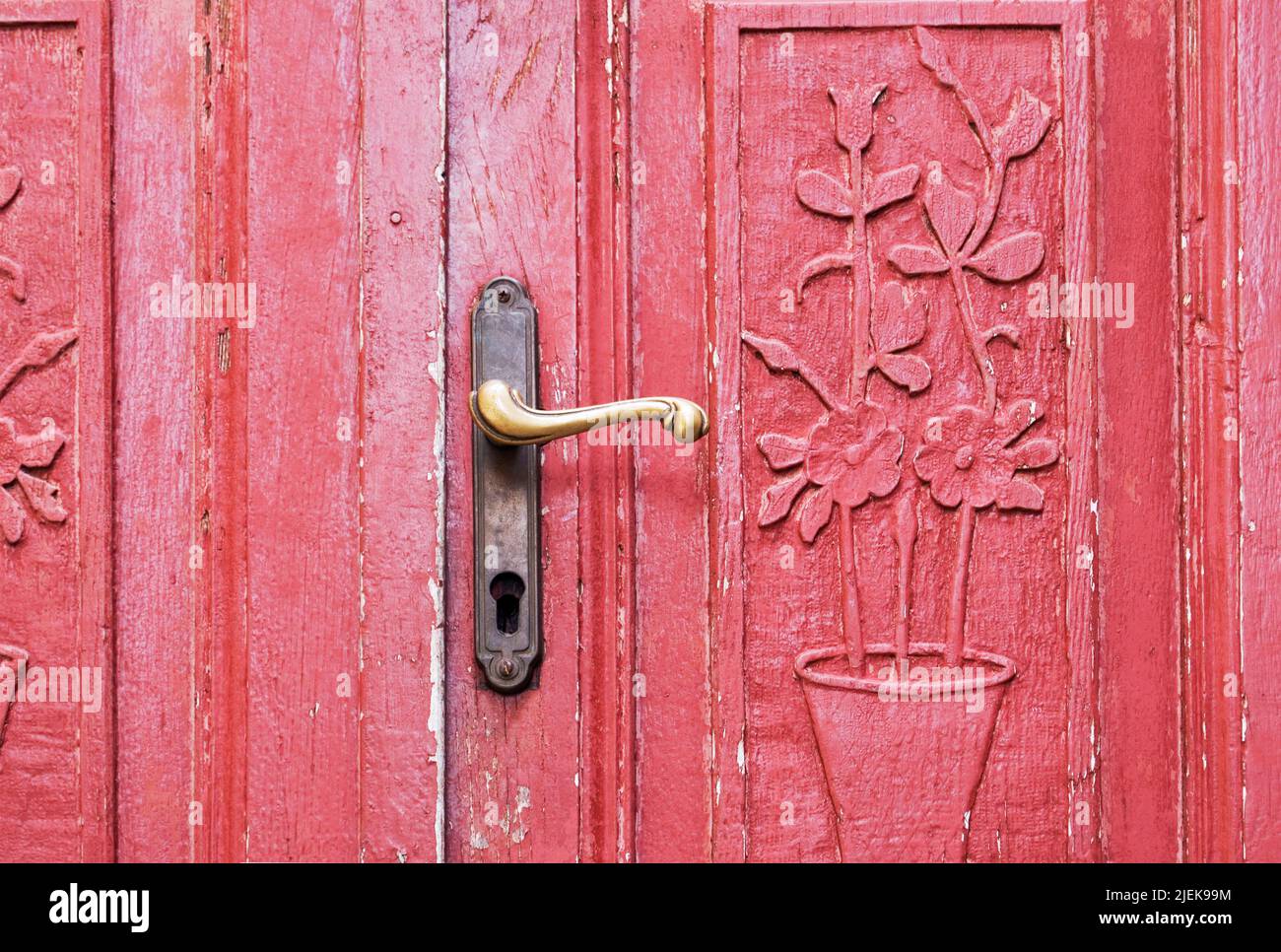 una antigua puerta roja con tallas ornamentales Foto de stock