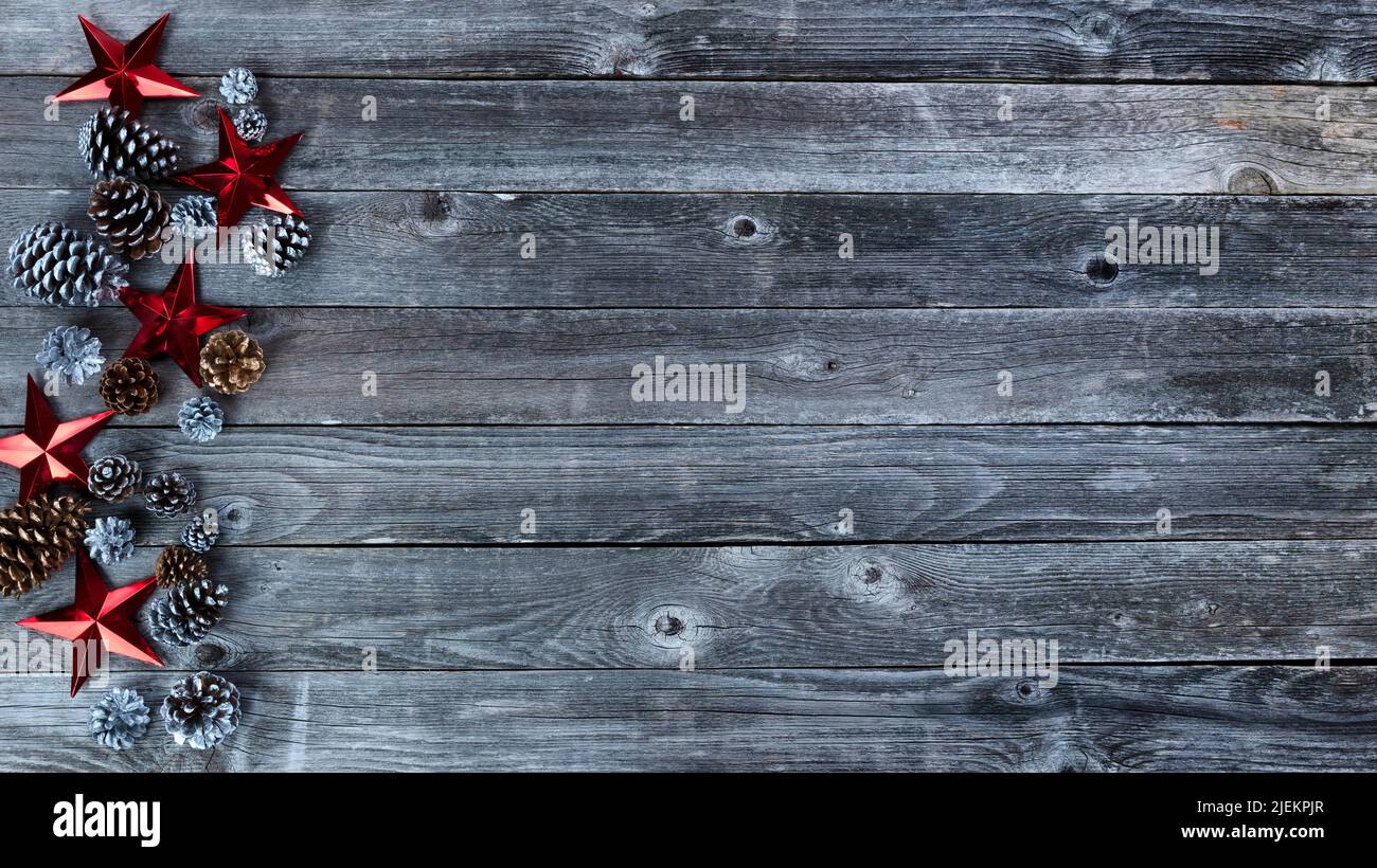 Conos de pino de oro y plata y estrellas rojas para la temporada navideña de Navidad o Año Nuevo en madera rústica Foto de stock